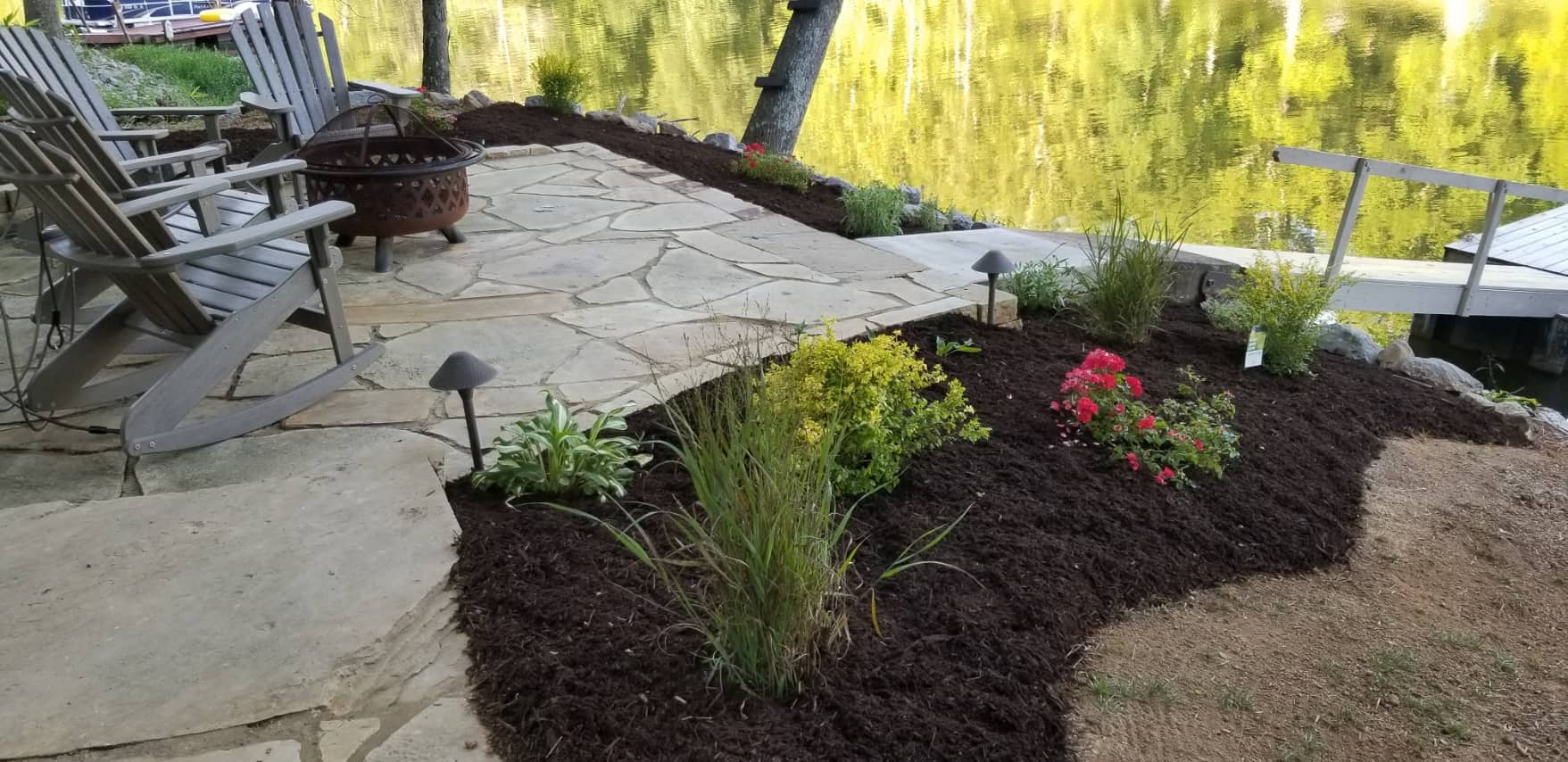 a covered back porch overlooking a mountain with built-in landscaping featuring native flowers