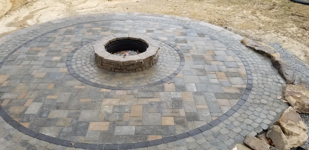 A gorgeous paver patio with a matching firepit.