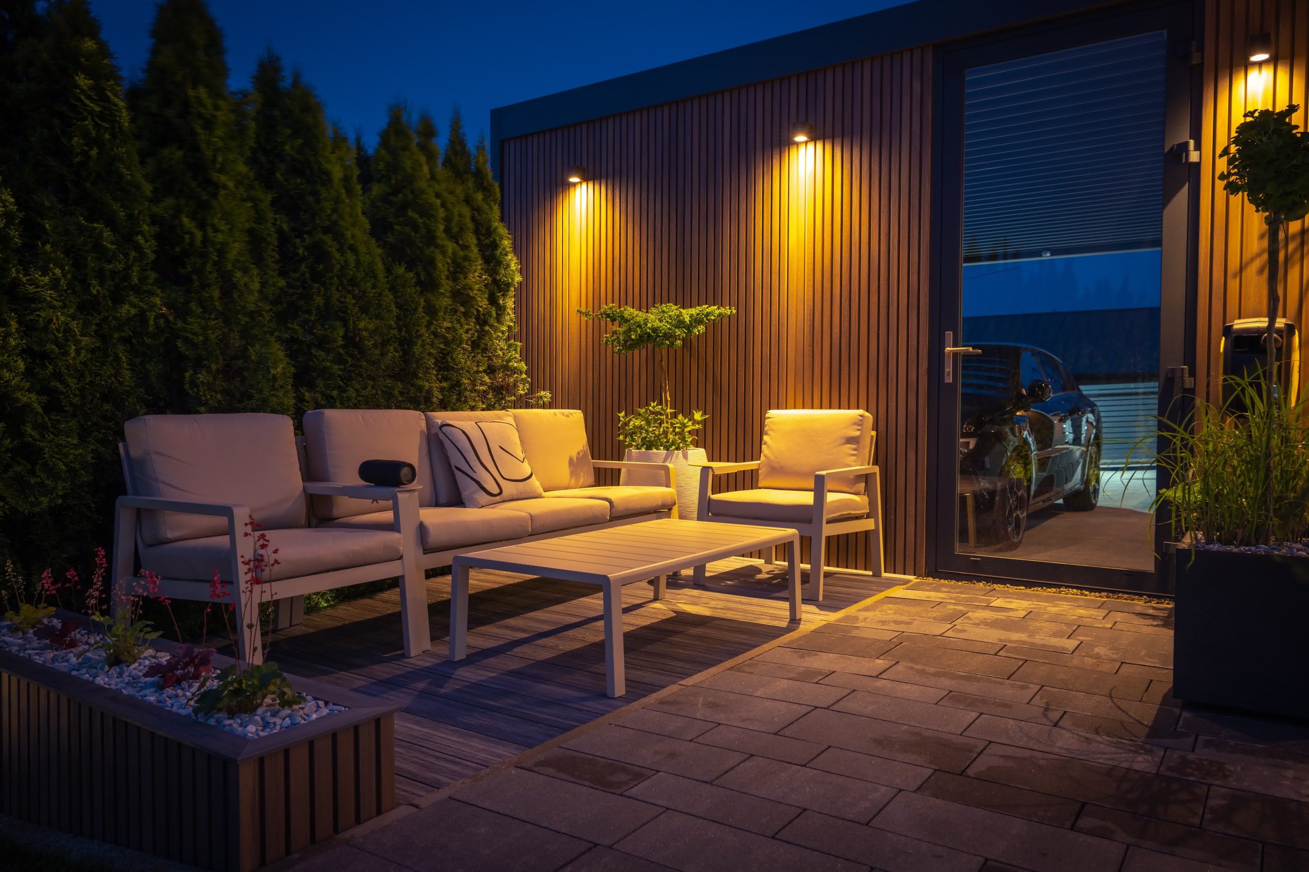 An outdoor living area with a cozy furniture set and dim lighting.