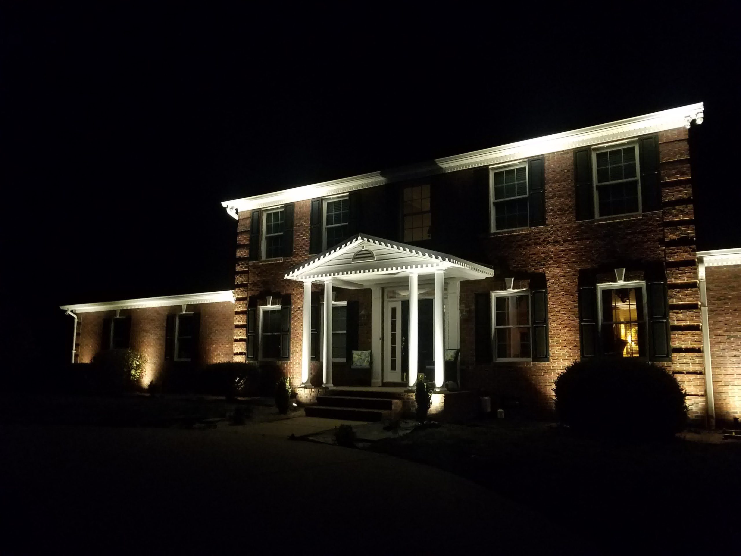 A home lit up at night from landscape lighting.